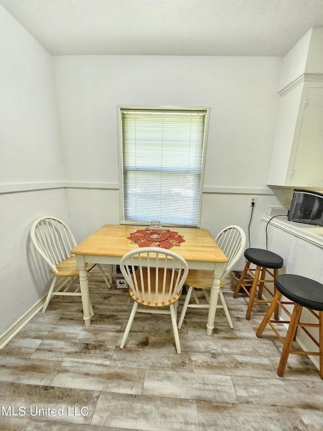 dining space featuring baseboards, breakfast area, and light wood-style floors