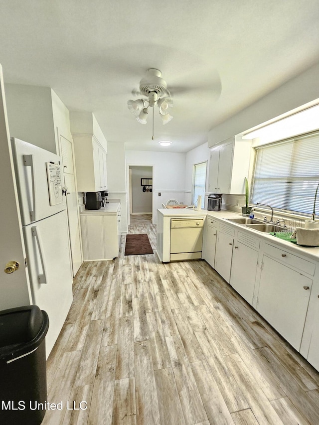 kitchen with ceiling fan, light wood-type flooring, a sink, light countertops, and white appliances