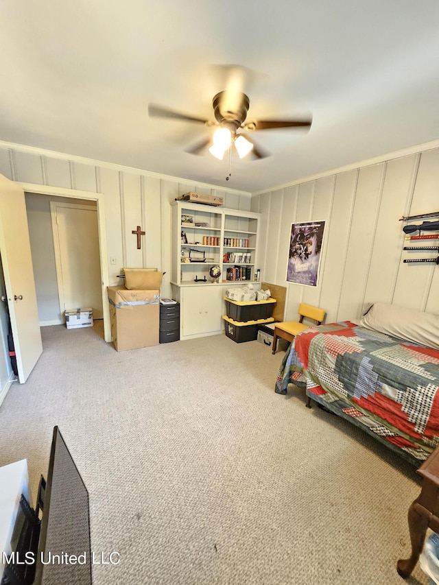 bedroom featuring carpet flooring, a ceiling fan, and a decorative wall