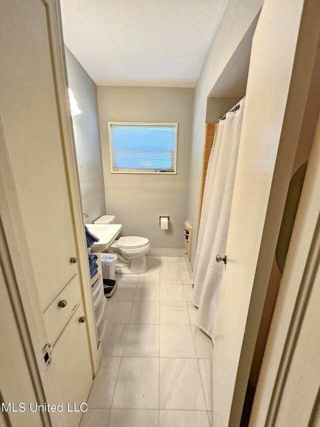 bathroom with toilet, tile patterned floors, and a shower with shower curtain