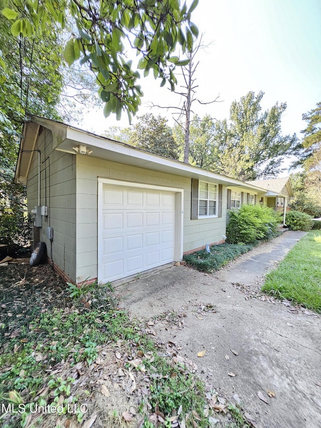 view of side of home with a garage and aphalt driveway