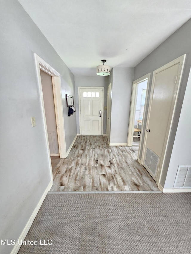 foyer featuring baseboards, visible vents, a wealth of natural light, and wood finished floors