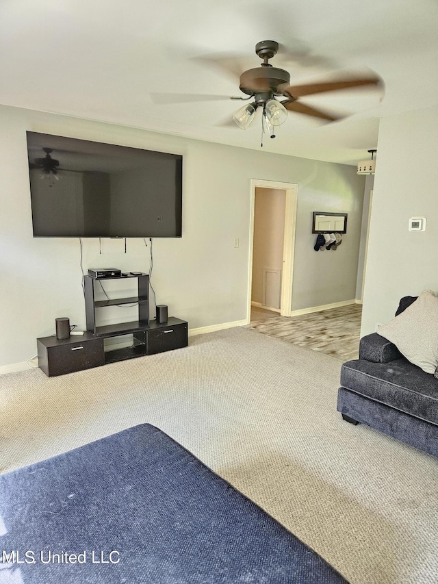 unfurnished living room featuring carpet floors, a ceiling fan, and baseboards