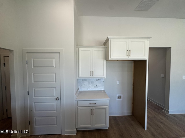 kitchen featuring dark wood-type flooring, white cabinets, visible vents, light countertops, and baseboards