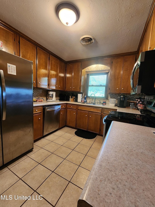 1365 Bruister Rd, Tutwiler, MS 38963 - kitchen with appliances with stainless steel finishes, a sink, tasteful backsplash, light countertops, and a textured ceiling