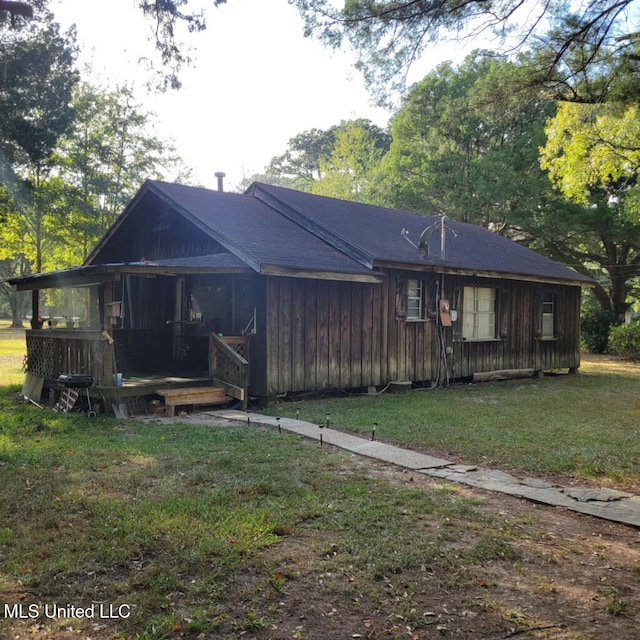 rear view of house featuring a lawn