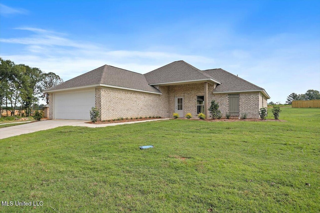 view of front of property with a garage and a front lawn