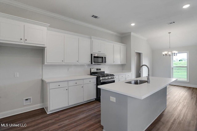 kitchen featuring backsplash, a kitchen island with sink, white cabinets, sink, and appliances with stainless steel finishes