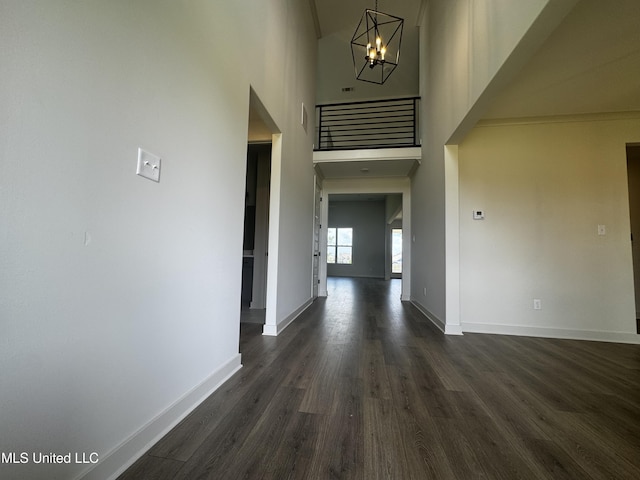 13721 River Grove Ln, Olive Branch, MS 38654 - hallway with a chandelier, dark wood finished floors, baseboards, and a high ceiling