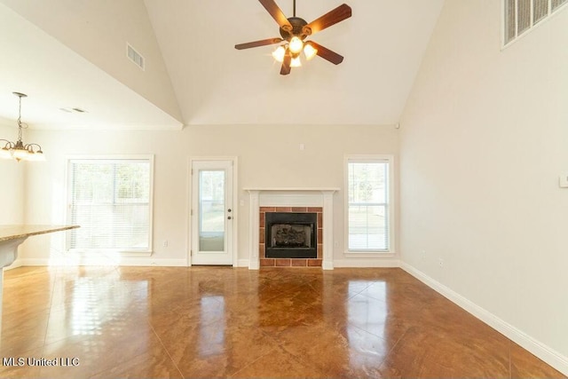 unfurnished living room with ceiling fan with notable chandelier, a fireplace, and high vaulted ceiling