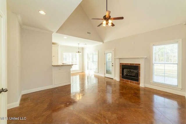 unfurnished living room featuring high vaulted ceiling, a tile fireplace, ceiling fan, and crown molding