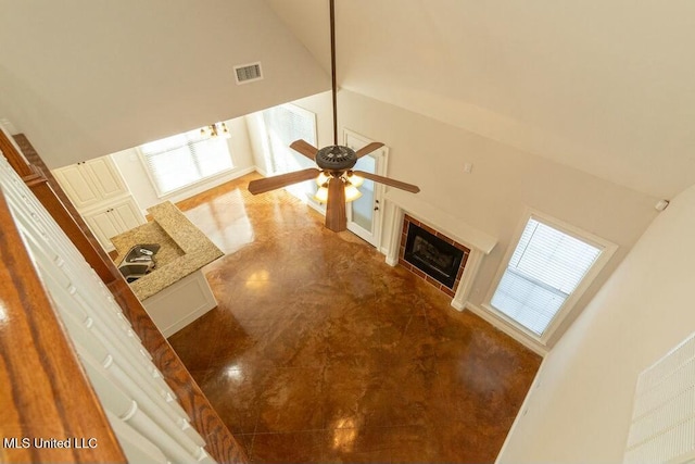 unfurnished living room featuring sink, high vaulted ceiling, ceiling fan, and plenty of natural light