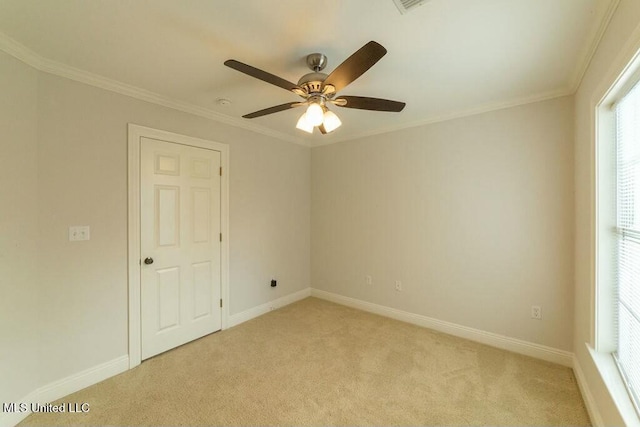 carpeted empty room featuring ceiling fan, ornamental molding, and a healthy amount of sunlight