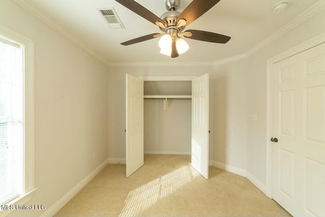 unfurnished bedroom with ceiling fan, light colored carpet, a closet, and crown molding