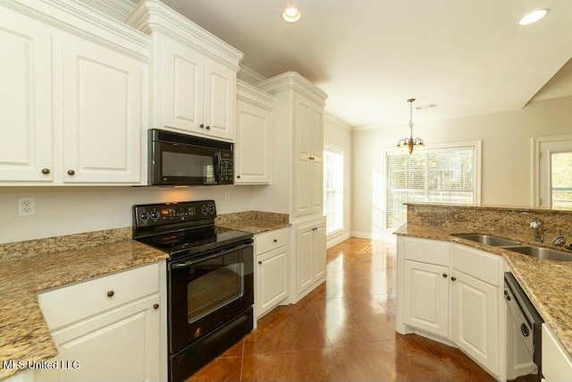 kitchen featuring black appliances, hanging light fixtures, light stone countertops, white cabinets, and sink