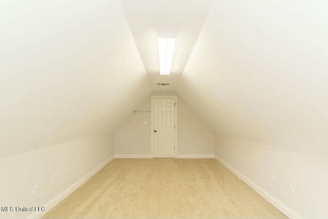 bonus room with light colored carpet and vaulted ceiling