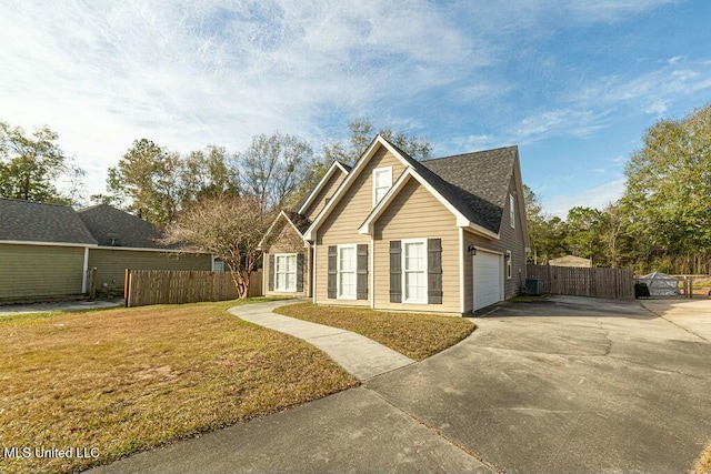 view of side of home with a lawn, central AC, and a garage