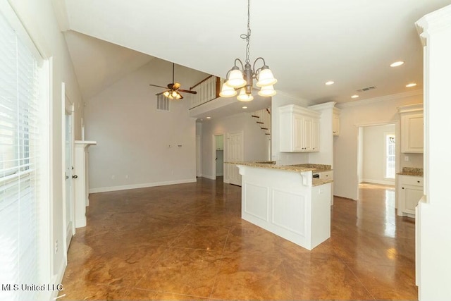 kitchen featuring white cabinets, light stone counters, dark tile patterned flooring, ornamental molding, and ceiling fan with notable chandelier