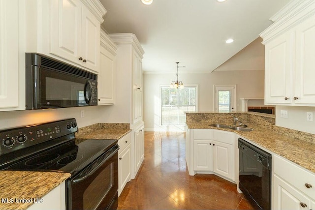 kitchen with light stone counters, hanging light fixtures, black appliances, white cabinets, and sink