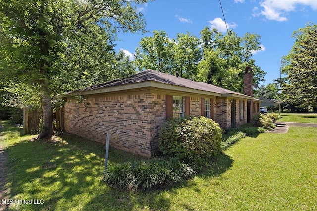 626 N Lexington St, Durant, MS 39063 - view of side of property featuring a yard, brick siding, and a chimney