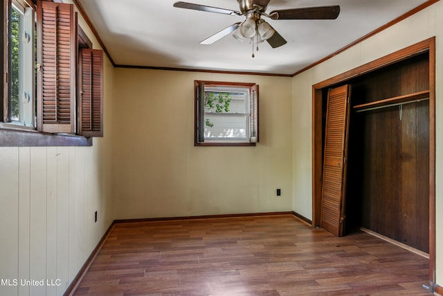 unfurnished bedroom featuring multiple windows, dark hardwood / wood-style floors, and ceiling fan