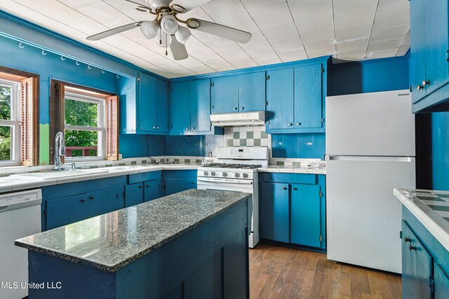 kitchen featuring dark hardwood / wood-style floors, ceiling fan, blue cabinets, and white appliances