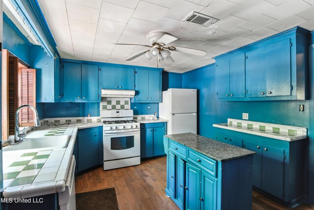 kitchen with blue cabinetry, dark hardwood / wood-style floors, and white appliances