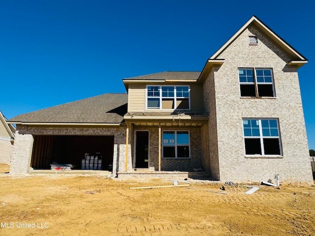 view of front facade with an attached garage and roof with shingles