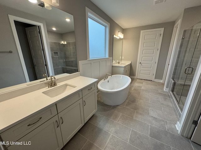 full bathroom featuring visible vents, a stall shower, two vanities, and a sink