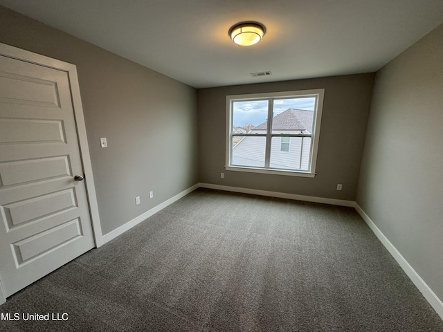 carpeted empty room with visible vents and baseboards