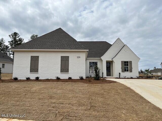 view of front of house featuring a front lawn and roof with shingles