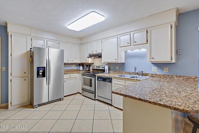 kitchen with sink, white cabinets, light tile patterned flooring, a textured ceiling, and stainless steel appliances