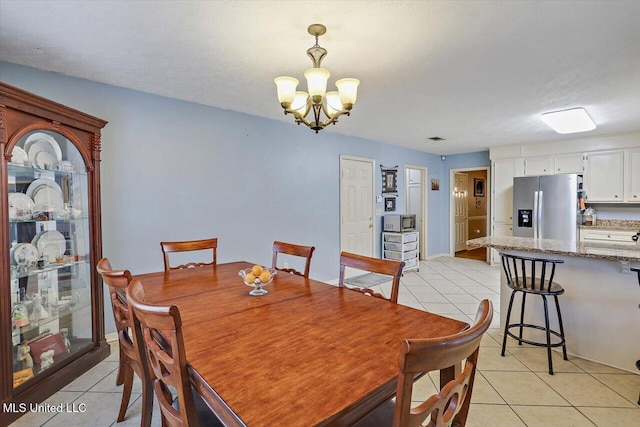 dining room with a textured ceiling, light tile patterned floors, and an inviting chandelier