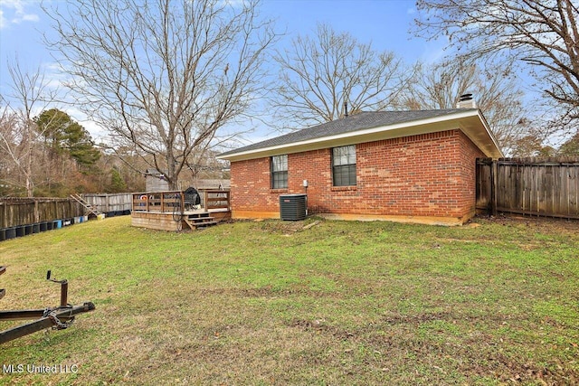 back of property featuring central AC unit, a wooden deck, and a yard