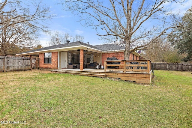 rear view of property with a yard and a deck