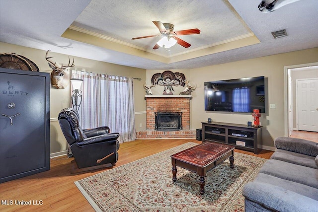 living room featuring hardwood / wood-style flooring, a raised ceiling, and a textured ceiling