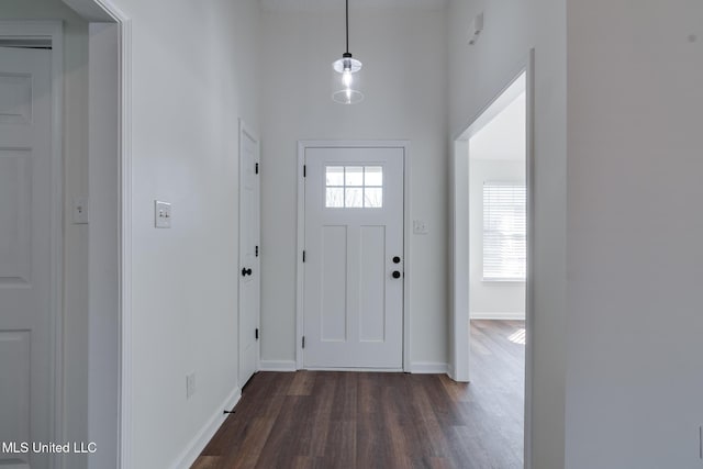 foyer featuring dark wood-type flooring and baseboards