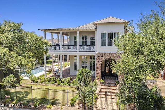 1511 18th Ave, Gulfport, MS 39501 - view of front facade with a balcony, a standing seam roof, metal roof, and brick siding