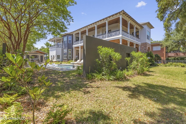 1511 18th Ave, Gulfport, MS 39501 - rear view of property with a yard, a balcony, an outdoor pool, and stucco siding