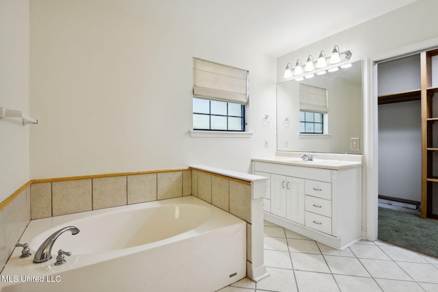 bathroom featuring vanity, a tub to relax in, and tile patterned flooring