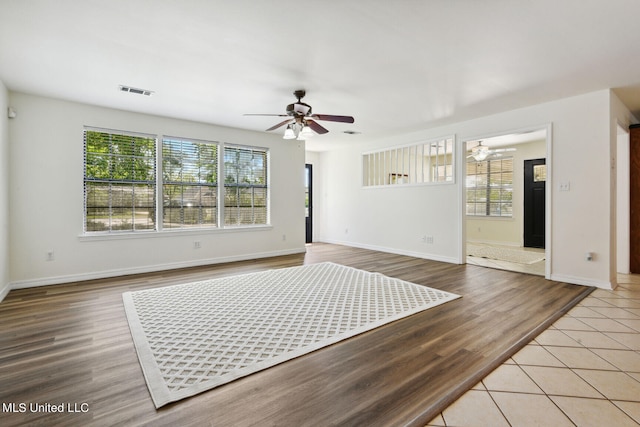 empty room featuring ceiling fan, plenty of natural light, and hardwood / wood-style floors