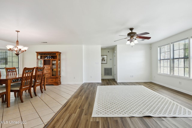 dining area featuring light hardwood / wood-style floors and ceiling fan with notable chandelier