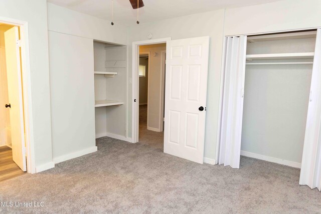 unfurnished bedroom with a closet, light colored carpet, and ceiling fan