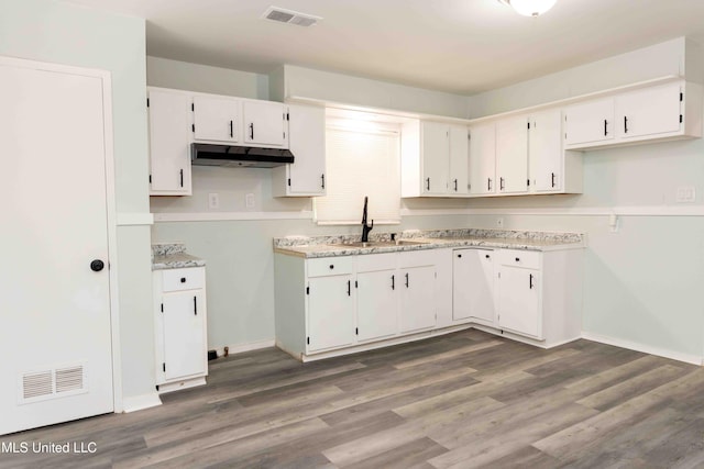 kitchen featuring dark hardwood / wood-style flooring, white cabinetry, and sink