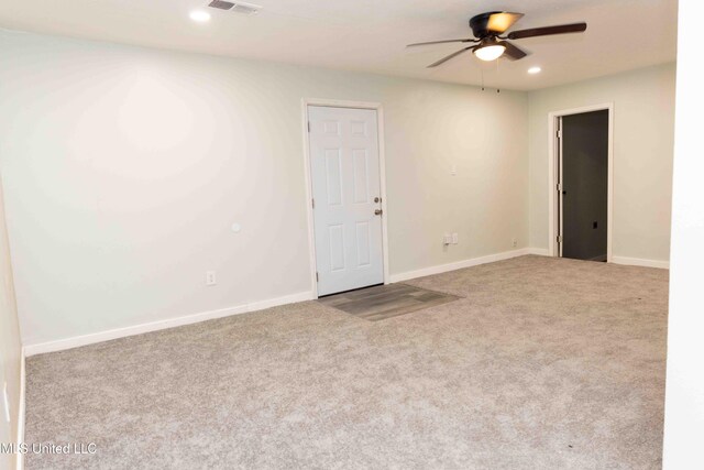 empty room featuring ceiling fan and light carpet