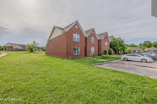 7241 Illinois Central Ave, Horn Lake, MS 38637 - view of side of home with brick siding, a lawn, and uncovered parking