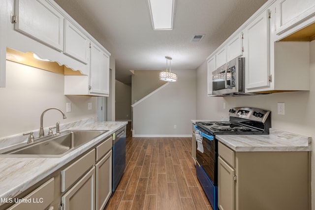 7241 Illinois Central Ave, Horn Lake, MS 38637 - kitchen with appliances with stainless steel finishes, a sink, dark wood-style flooring, light countertops, and white cabinets