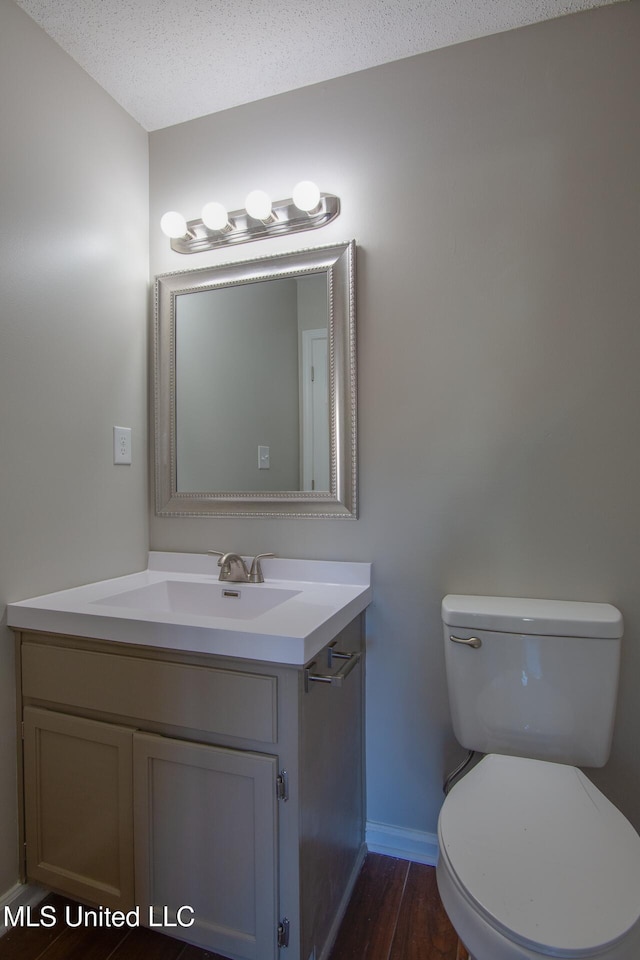 7241 Illinois Central Ave, Horn Lake, MS 38637 - half bath featuring baseboards, vanity, toilet, and wood finished floors