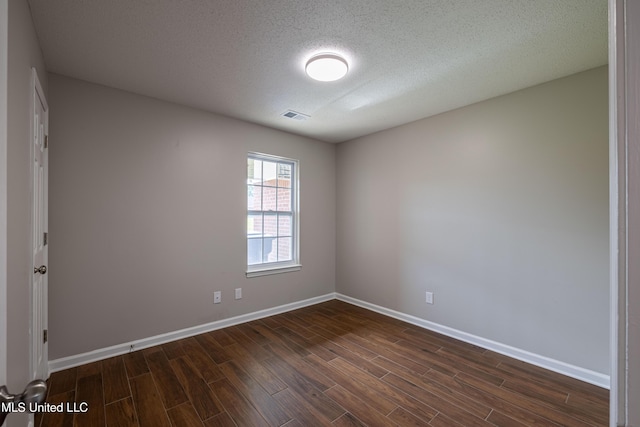 7241 Illinois Central Ave, Horn Lake, MS 38637 - spare room featuring dark wood-style flooring, baseboards, and a textured ceiling