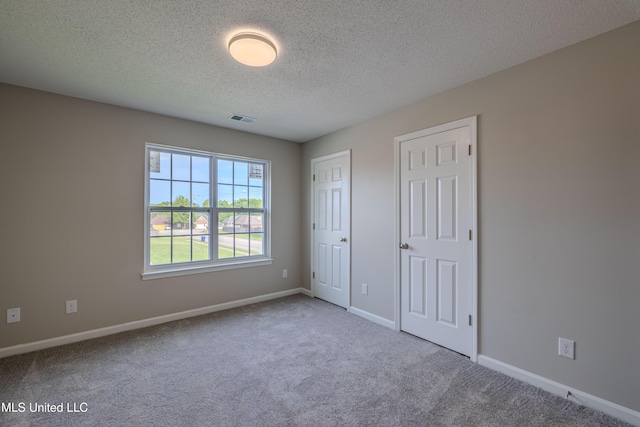 7241 Illinois Central Ave, Horn Lake, MS 38637 - unfurnished bedroom featuring carpet, a textured ceiling, baseboards, and multiple closets